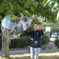 adolescent creant d enormes bulles de savon avec un cadre so