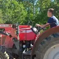 jeune homme conduisant un tracteur massey ferguson rouge mfr